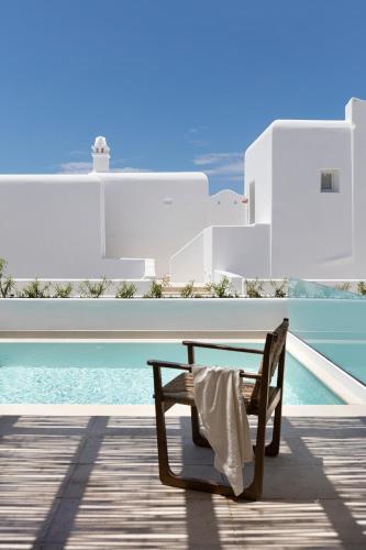 a wooden bench sitting on a deck next to a pool at Porto Mykonos in Mýkonos City