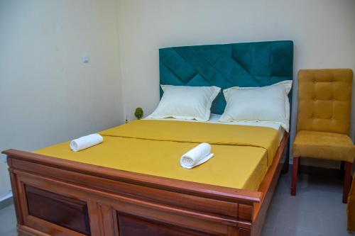 a bed with two white towels on top of it at New 237 de Luxe in Yaoundé