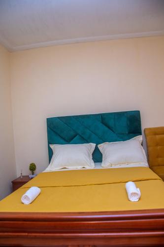 a bedroom with a large bed with a green headboard at New 237 de Luxe in Yaoundé