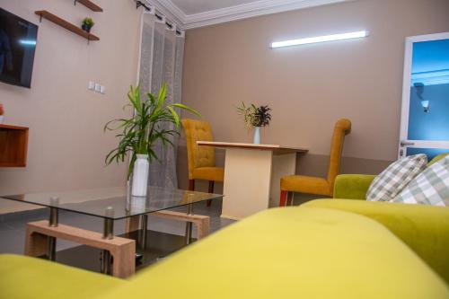 a living room with a couch and a table and chairs at New 237 de Luxe in Yaoundé