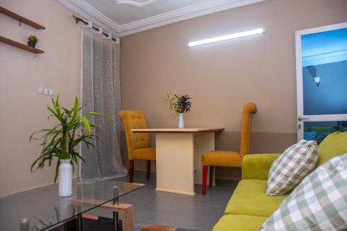 a living room with a couch and a table and chairs at New 237 de Luxe in Yaoundé