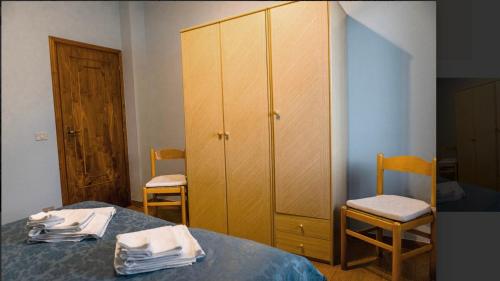a bedroom with a bed and a cabinet and two chairs at Villa Paradiso Brenzone in Brenzone sul Garda