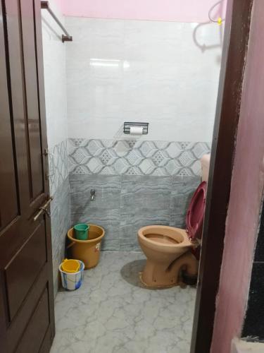 a bathroom with a toilet and buckets in it at Garden Villa, Hyderabad in Hyderabad