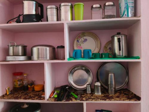 a shelf filled with pots and pans and dishes at Garden Villa, Hyderabad in Hyderabad