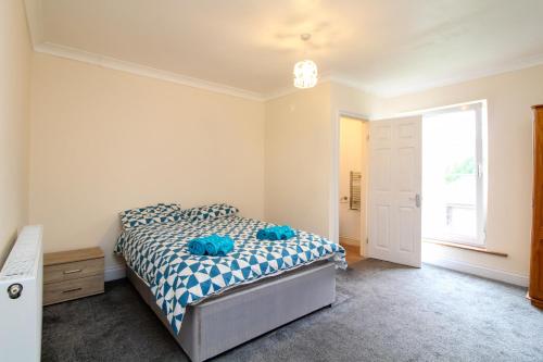 a bedroom with a bed with blue pillows on it at Darwin road guest house 5 in Southampton