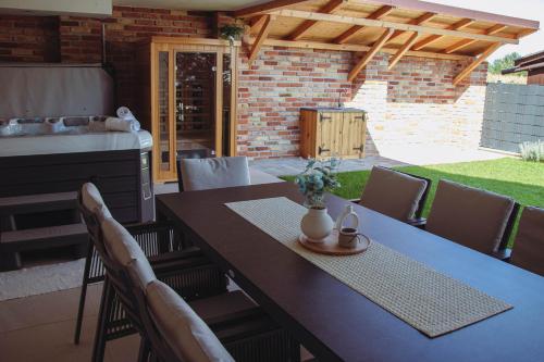 a dining table with chairs and a kitchen in a backyard at Nagy-Zátonyi Vendégház in Dunasziget