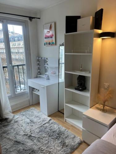 Cette chambre dispose d'une étagère blanche et d'un bureau. dans l'établissement Appartement Paris vue Tour Eiffel Trocadéro, à Paris