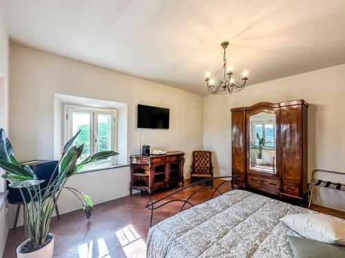 a bedroom with a bed and a desk and window at Villa Naldi Relais in San Carlo