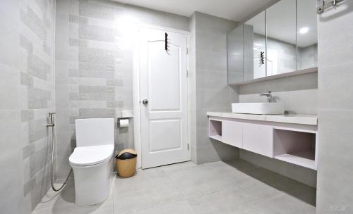 a white bathroom with a toilet and a sink at Eco Nest Apartment & Hotel Nam Ngư in Hanoi