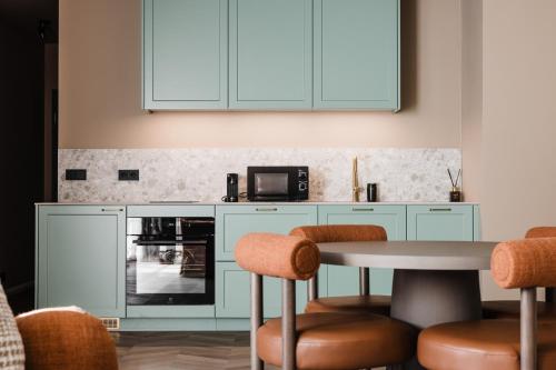 a kitchen with blue cabinets and a table with chairs at Reykjavik Residence Apartment Hotel in Reykjavík