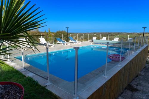 a swimming pool with a fence around it at Grange avec vue, proche de Sarlat, calme et dépaysement au coeur du Lot in Beaumat