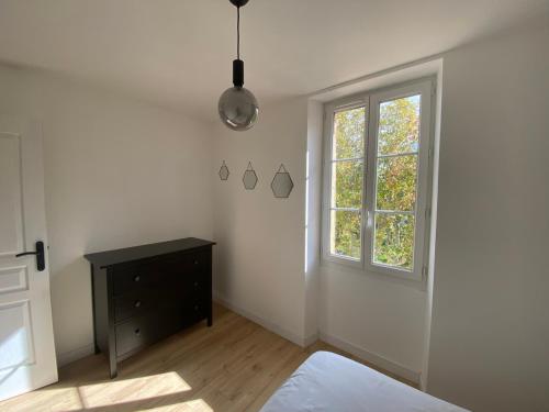 Cette chambre blanche dispose d'une fenêtre et d'une commode noire. dans l'établissement Havre de paix au sein d'un T3 d'une bastide aixoise, à Aix-en-Provence