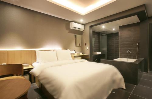 a bedroom with a large bed and a bath room at Zenith Hotel Bupyeong in Incheon