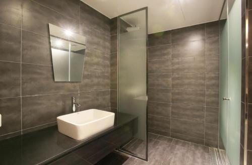 a bathroom with a sink and a mirror at Zenith Hotel Bupyeong in Incheon