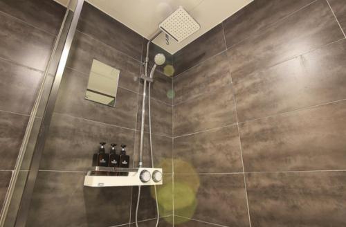 a bathroom with a shower with bottles on a shelf at Zenith Hotel Bupyeong in Incheon