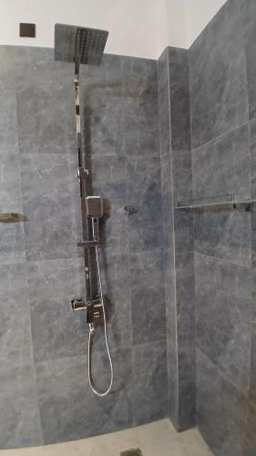 a shower with a glass door with a shower head at Coco Mount Residence - Hiriketiya in Dickwella