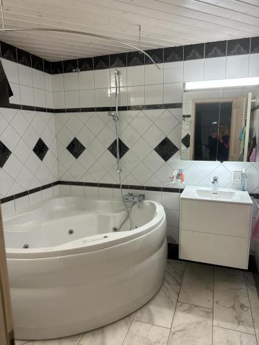 a white bathroom with a tub and a sink at Anna 1 in Grächen