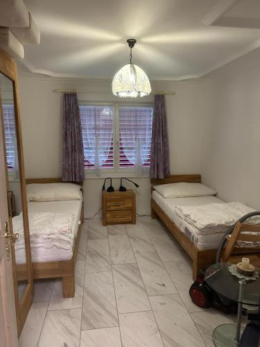 a bedroom with two beds and a table and windows at Anna 1 in Grächen
