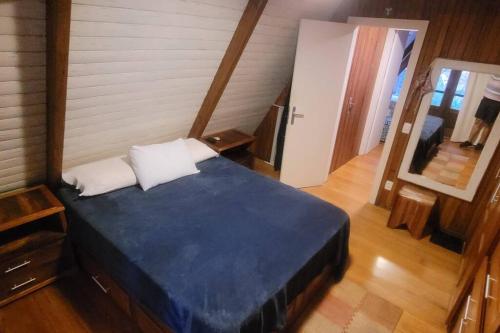 a bedroom with a blue bed in a room at Chalé no Chamonix de Itaipava in Petrópolis