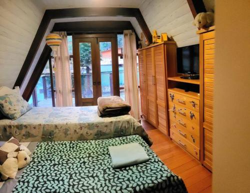 a bedroom with a bed and a tv in a room at Chalé no Chamonix de Itaipava in Petrópolis