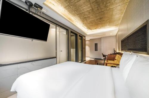 a bedroom with a large white bed and a television at Zenith Hotel Bupyeong in Incheon