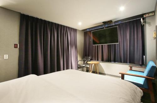 a hotel room with a bed and a television at Zenith Hotel Bupyeong in Incheon