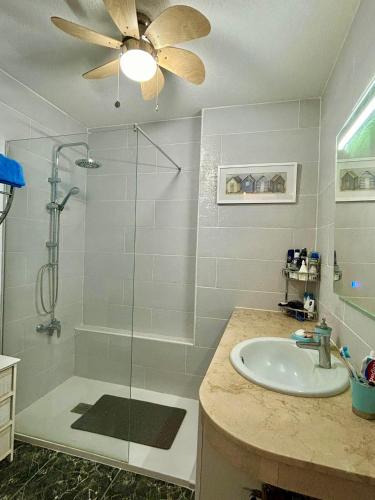 a bathroom with a shower and a sink and a ceiling fan at Ocean View Tenerife South Coast in Costa Del Silencio