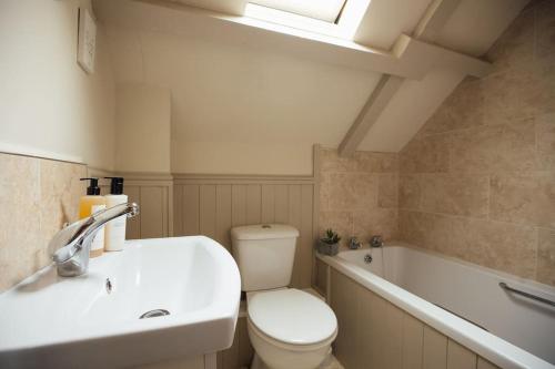 a bathroom with a toilet and a sink and a bath tub at Oak Cottage at Scolton Cottages - Indoor pool in HAW
