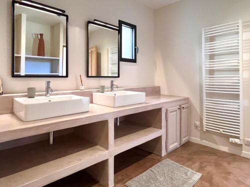 une salle de bain avec deux lavabos et deux miroirs dans l'établissement La Calade de Goult, à Goult