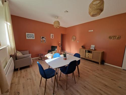 un salon avec une table et des chaises bleues dans l'établissement Les appartements de Lucie, à Eaux-Bonnes