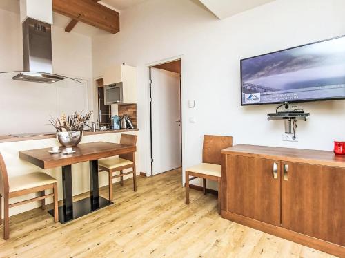 a kitchen and dining room with a table and a television on the wall at Apartment Emma-8 by Interhome in Dürnberg
