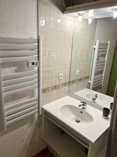 un baño con lavabo y espejo en Appartement 5 personnes - Lumière des Neiges A 209, en Valmeinier