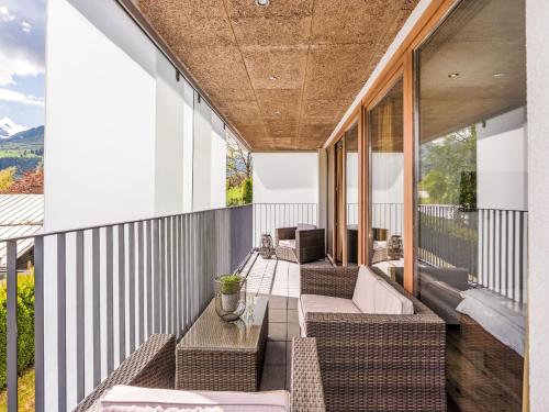 an outdoor balcony with wicker chairs and a couch at Apartment Emma-8 by Interhome in Dürnberg