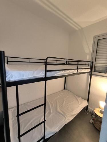 une chambre avec deux lits superposés dans une pièce dans l'établissement La Désirade avec Parking- Port - WIFI couchage en 160 neuf, au Cap d'Agde