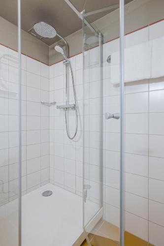 a shower with a glass door in a bathroom at Grand Hotel Viljandi in Viljandi