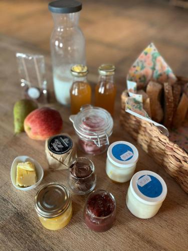 a table with different types of food and a basket of bread at Les Tiny du Pré Mathy - Logements insolites avec Jacuzzi à Profondeville in Profondeville