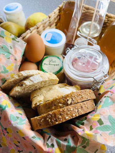 a basket filled with bread and eggs and other ingredients at Les Tiny du Pré Mathy - Logements insolites avec Jacuzzi à Profondeville in Profondeville