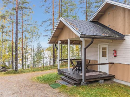 a cabin with a porch on the side of a house at Holiday Home Papula by Interhome in Puumala