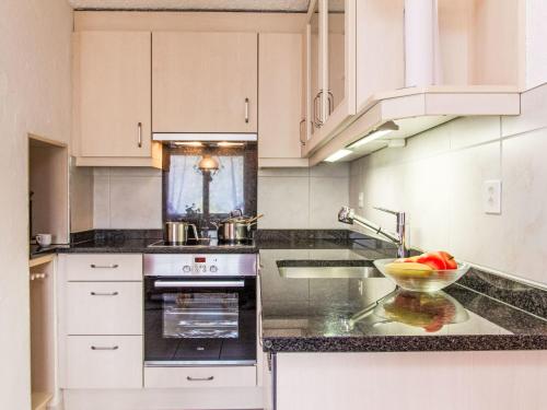 a kitchen with white cabinets and a sink at Chalet Dominic by Interhome in Saclentse