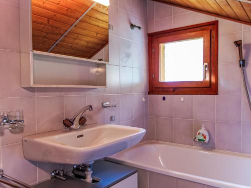 a bathroom with a sink and a tub and a window at Chalet Dominic by Interhome in Saclentse