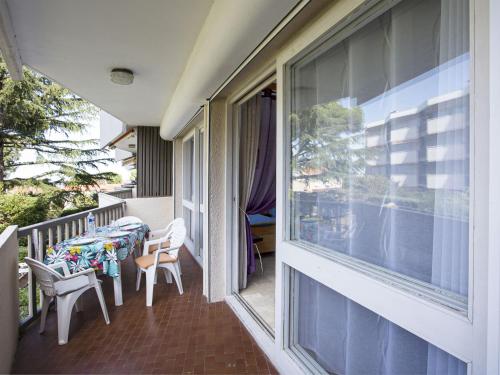 d'un balcon avec des tables, des chaises et une fenêtre. dans l'établissement Apartment Le Racou by Interhome, à Argelès-sur-Mer