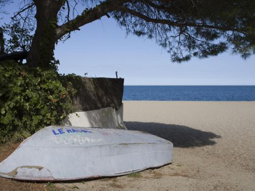 un bateau assis sur la plage à côté d'un arbre dans l'établissement Apartment Le Racou by Interhome, à Argelès-sur-Mer