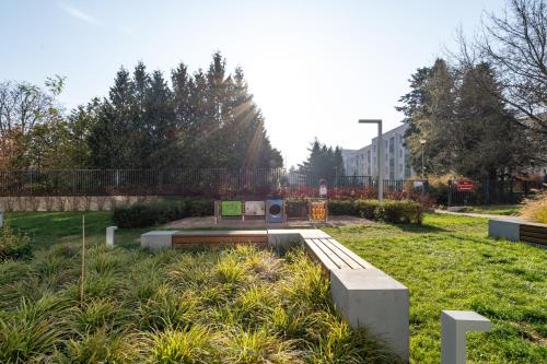 a park with a bench in the grass at SuperApart Sternicza apt 43 in Warsaw