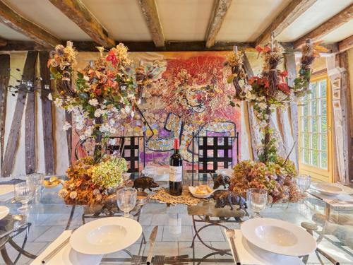 a dining room with a table with glasses and flowers at Holiday Home La longère by Interhome in Vatteville-la-Rue