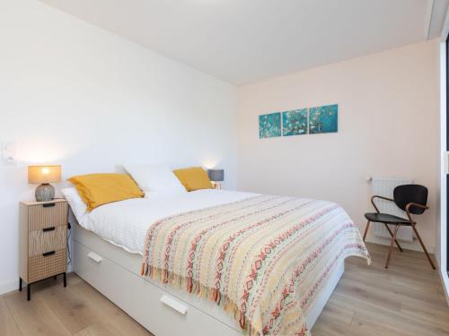 une chambre blanche avec un lit et une chaise dans l'établissement Apartment Résidence de l'Hermine by Interhome, à Saint-Malo