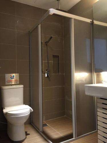 a bathroom with a shower with a toilet and a sink at D Elegance Hotel Nusajaya in Nusajaya