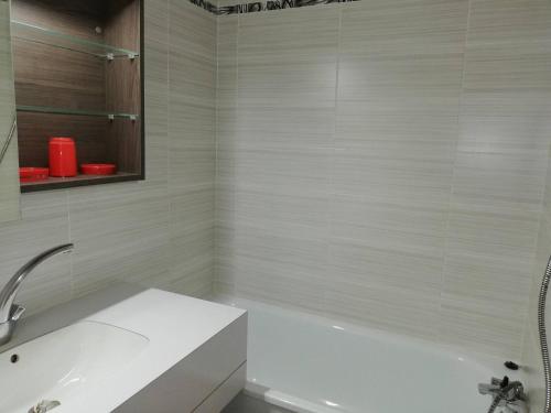 une salle de bain blanche avec une baignoire et un lavabo dans l'établissement Appartement spacieux avec balcon, animaux acceptés - Valmorel - FR-1-356-298, à Valmorel