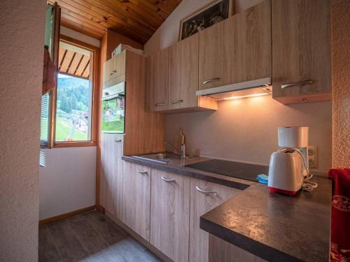 une cuisine avec des armoires en bois et un comptoir dans l'établissement Appartement spacieux avec balcon, animaux acceptés - Valmorel - FR-1-356-298, à Valmorel