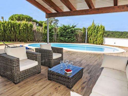 a patio with chairs and a swimming pool at Holiday Home Torre de Ven by Interhome in Vidreres