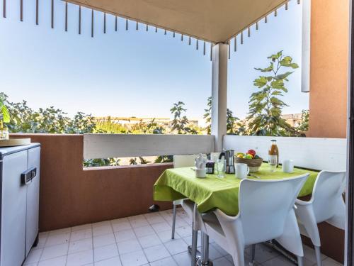 a table with a green table cloth on a balcony at Apartment Primavera-4 by Interhome in Agde